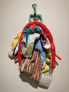 Kelsey Tynik ’12 (SFA), ’23 MFA created the wall sculpture “And cry at the same time when a capering circus clown approaches," on display at the William Benton Museum of Art until May 7.