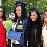 A graduate poses for a photo with family