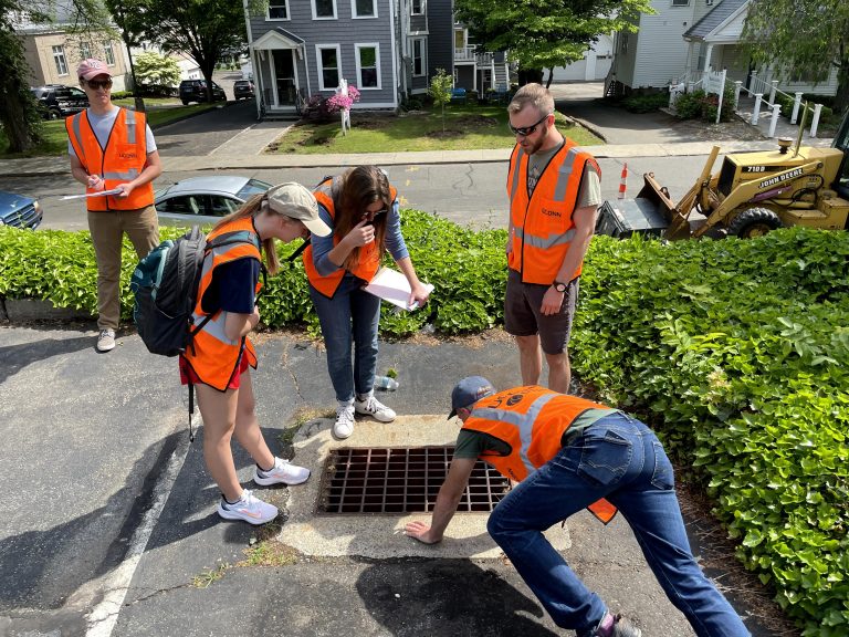 Stormwater Corps students evaluate parking lot drainage with the help of Dr. Mike Dietz and GA Josh Snarski