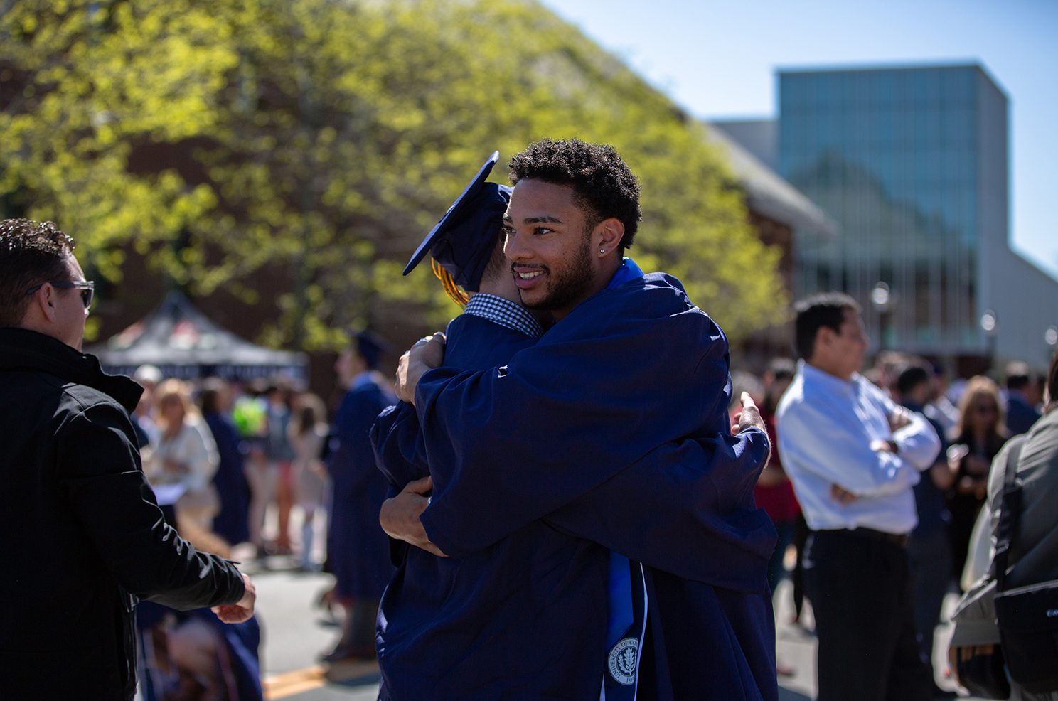 Graduates embrace outside Gampel Pavilion.