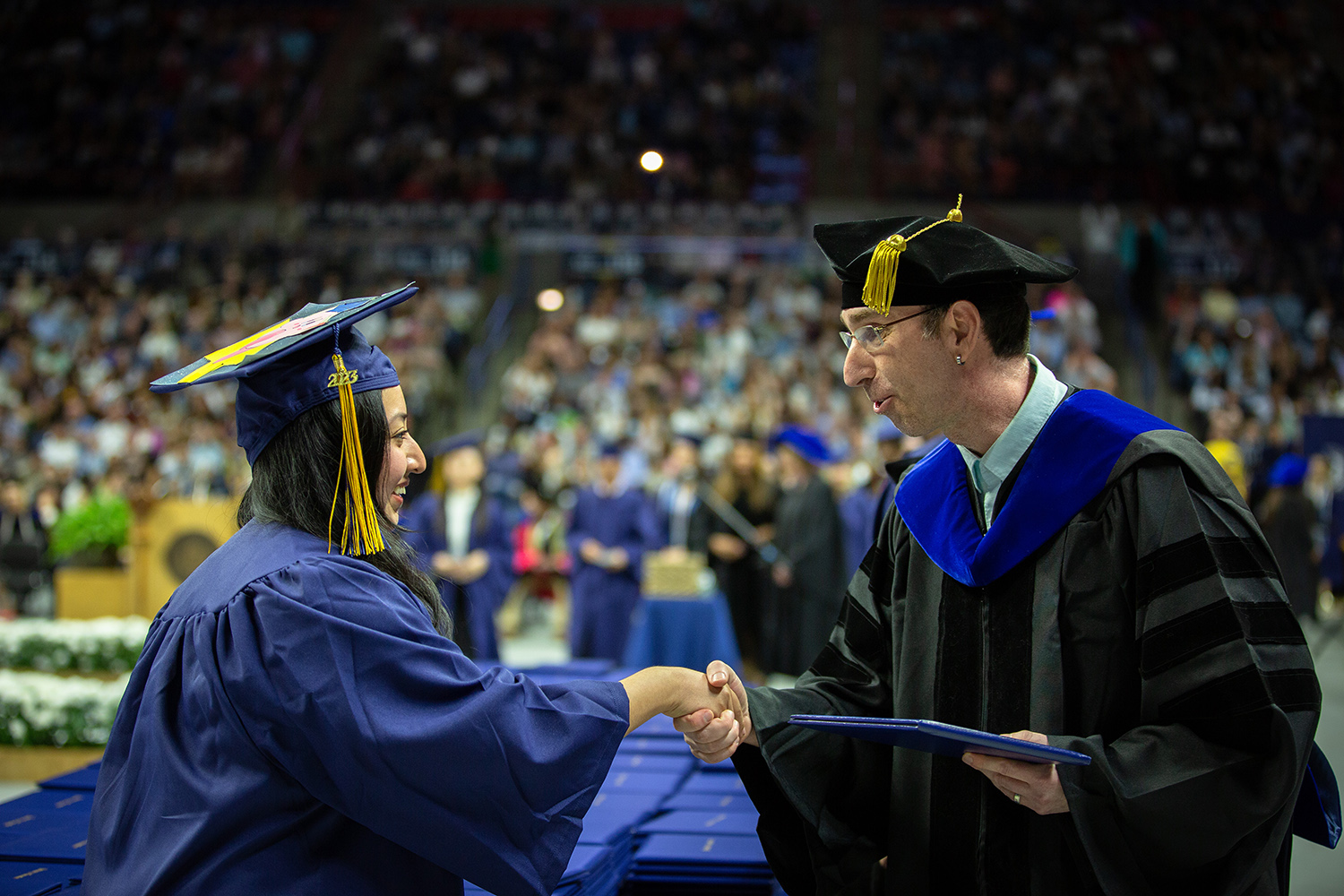 Ofer Harel shakes a graduate's hand during commencement.