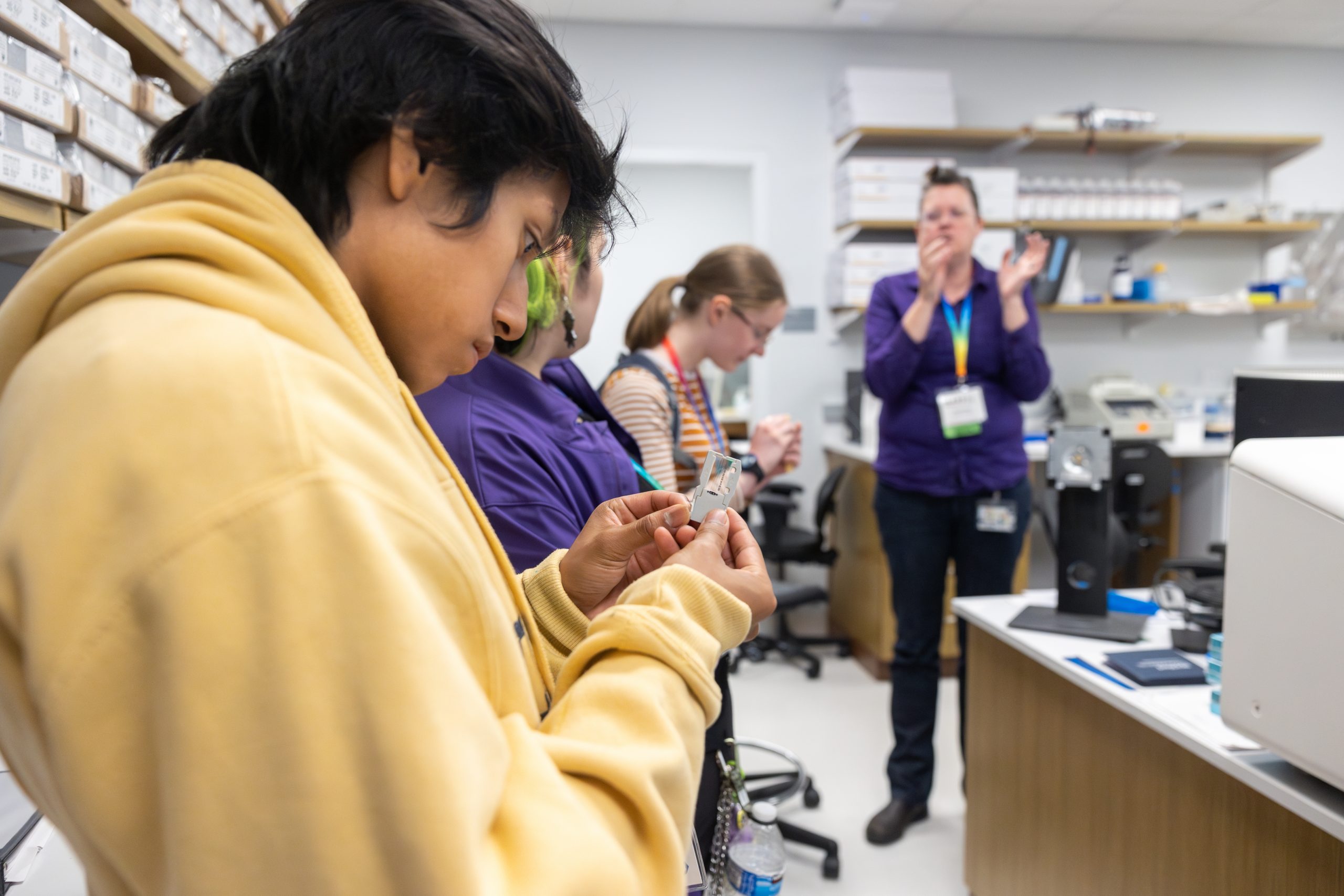 Conard High School student Jojo Painter holds a part for one of the imaging systems in MARS’ sequencing lab as Kendra Maas walked their group through the MARS lab