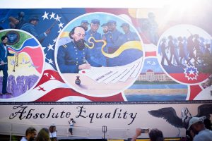 People take pictures next to a mural during a Juneteenth celebration in Galveston, Texas, on June 19, 2021. 