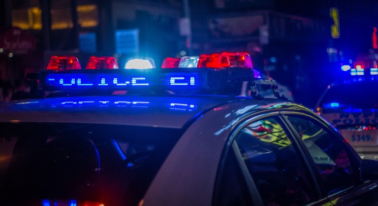 The lights on top of a police car are illuminated.
