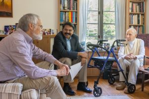 William Aho (right), a UConn natural science professor emeritus and currently the oldest living UConn professor at 105 years old, chats with his son, Paul Aho, left, and CAHNR Associate Dean for Research and Graduate Studies Kumar Venkitanarayanan, center, in his home in Mansfield