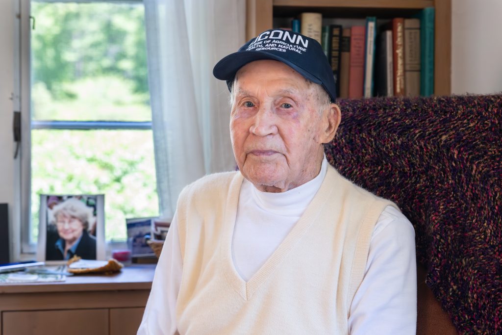 William Aho, a UConn natural science professor emeritus and currently the oldest living UConn professor at 105 years old, poses for a photo in his home in Mansfield