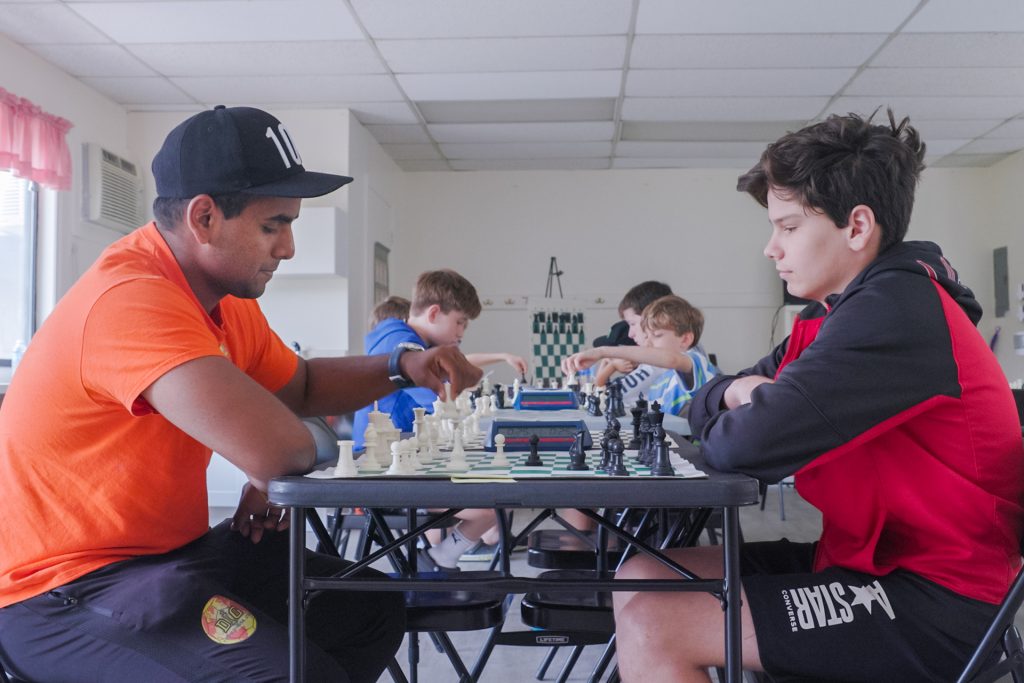 Jithu Sajeevan, left, a UConn Stamford student and co-owner of DIG USA, plays a round of chess with one of his students during a chess tournament at the Our Lady of Fatima School in Wilton