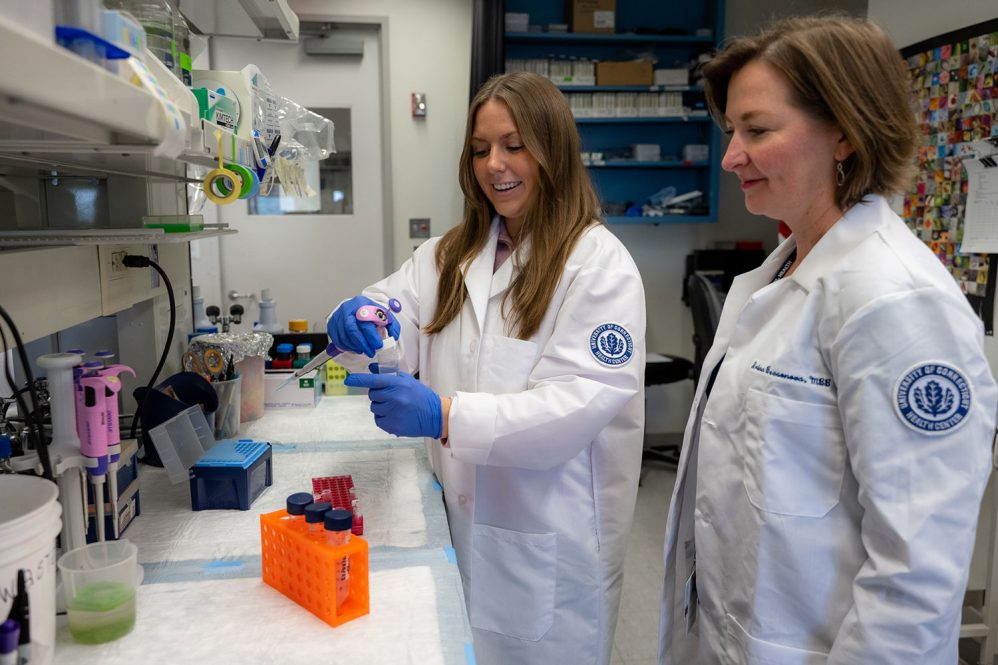 Two women in lab coats working in a lab