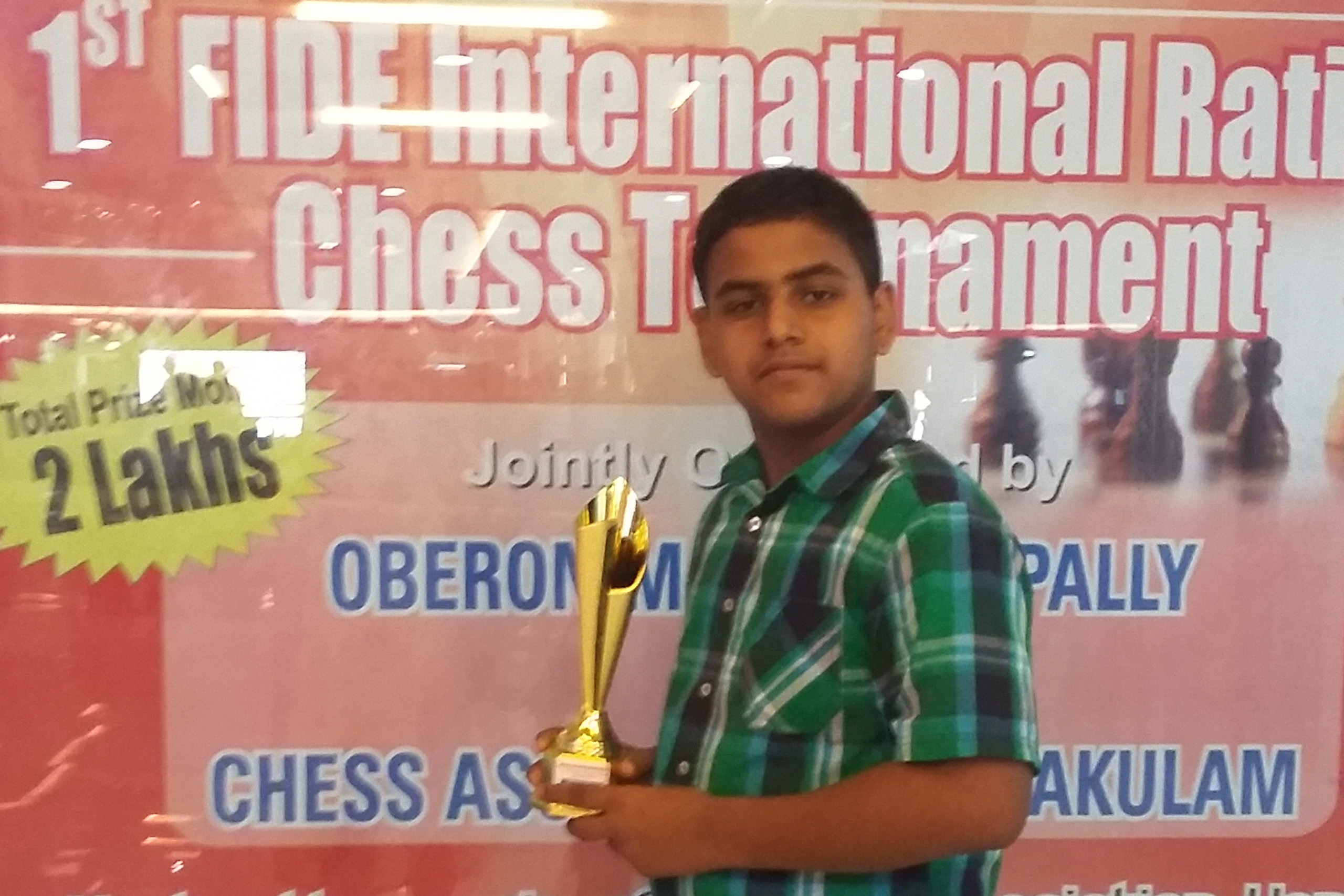 Jithu holding a trophy he won at a chess tournament as a kid.