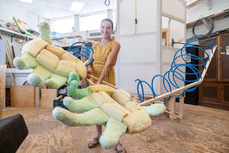 Joanie Papillon '24 (SFA), poses with the current progress of her puppetry project