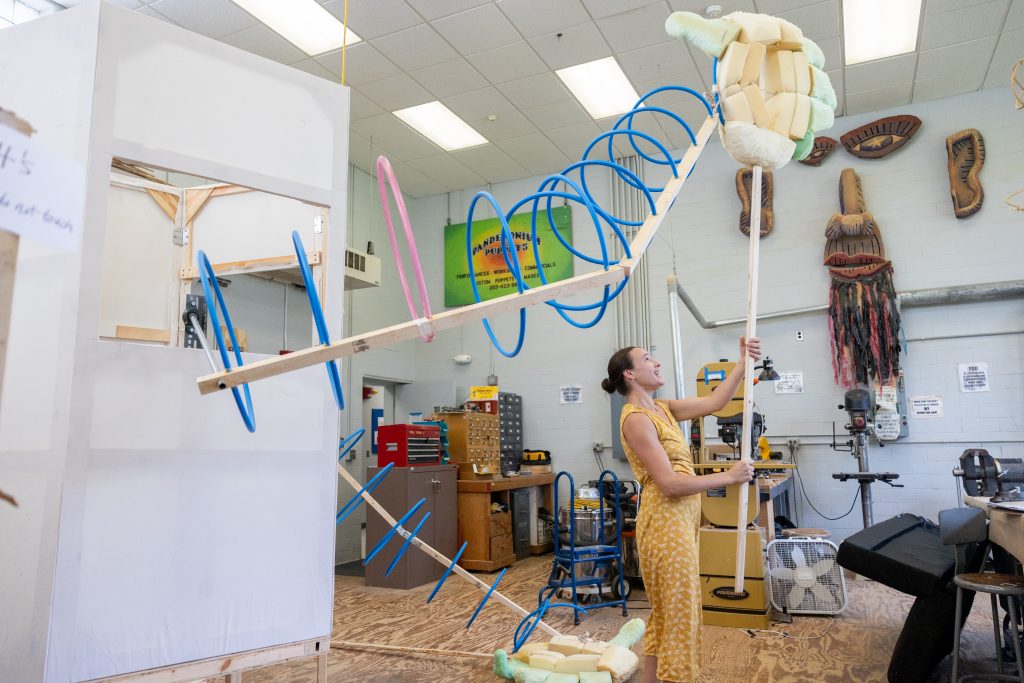 Joanie Papillon '24 (SFA), holds up one of the large arms that are part of her puppetry project, "Taurus: An Original Multidisciplinary Theatre Production," in her workspace in the Puppet Arts Complex