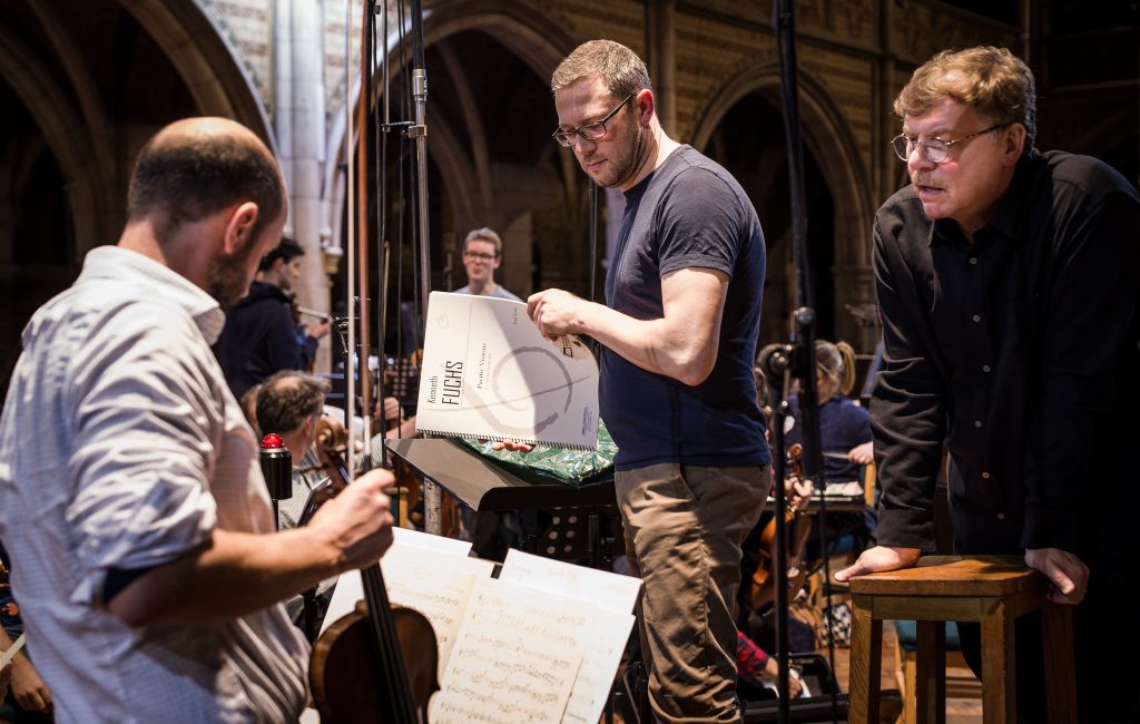 Composer and UConn music composition professor Kenneth Fuchs, right, works with U.K. conductor John Wilson, center, and musician John Mills, at left with the violin, to record "Cloud Slant" with the Sinfonia of London. The album was released in July.