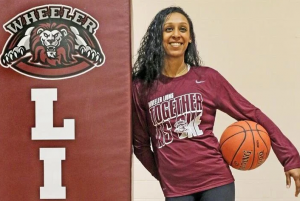 Woman of color with maroon school t-shirt and basketball.