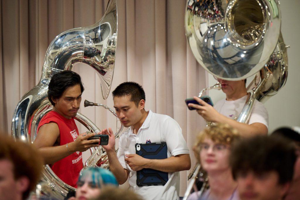 Justin McManus '11 (SFA, ED) '13 MM, director of athletic bands, speaks with sousaphone players during a UConn Marching Band practice at the Music Building on Aug. 21, 2023.