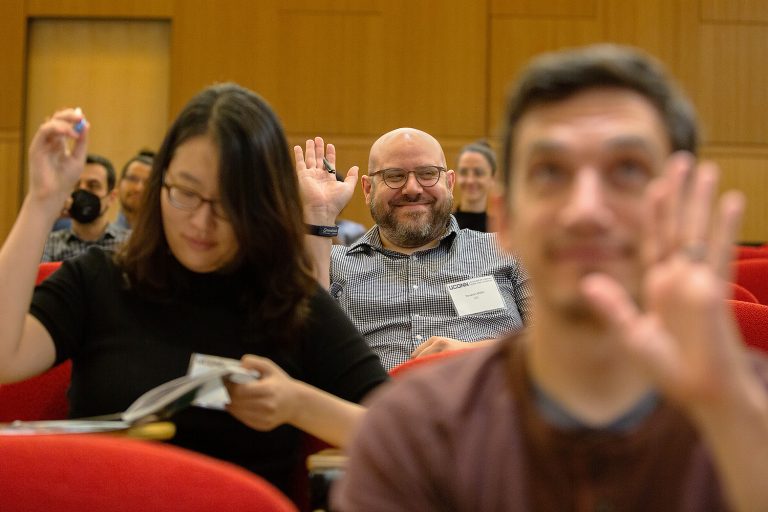 People raising their hand while participating in a new faculty orientation.