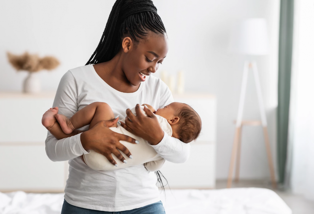 A woman holds an infant in her arms.