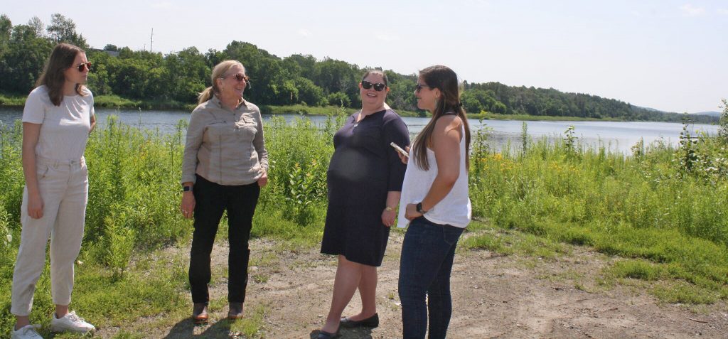 Karen Gorman and Penny Thompson speak with Katie Malgioglio and Randi Mendes near the Aroostook River.