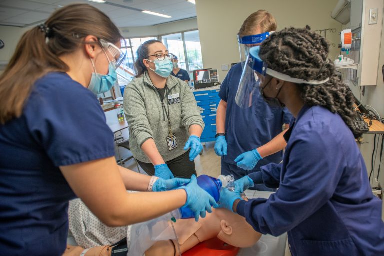 Students receiving instruction on performing CPR in a School of Nursing Simulation Lab.