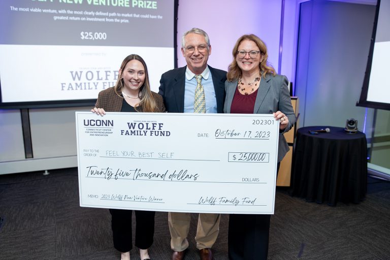Emily Wicks, Gary Wolff, and Sandy Chafouleas pose with the $25,000 check following the Wolff New Venture Competition. Wicks and Chafouleas are the founders of Feel Your Best Self, which won the top award. Photo by Alex Syphers/Defining Studios