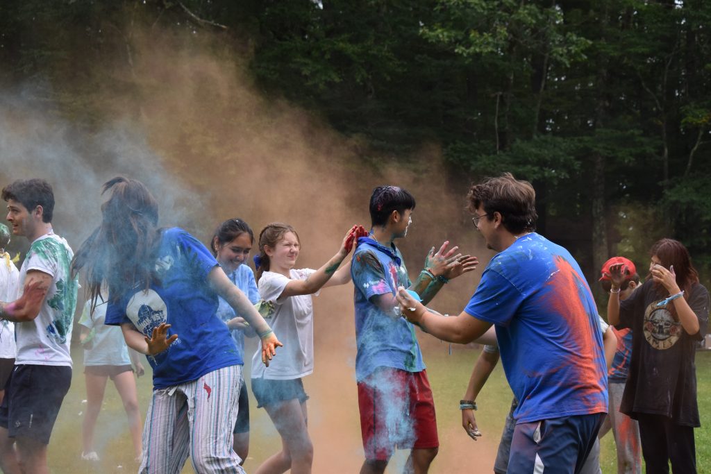 Students and counselors throw colorful powder at each other.