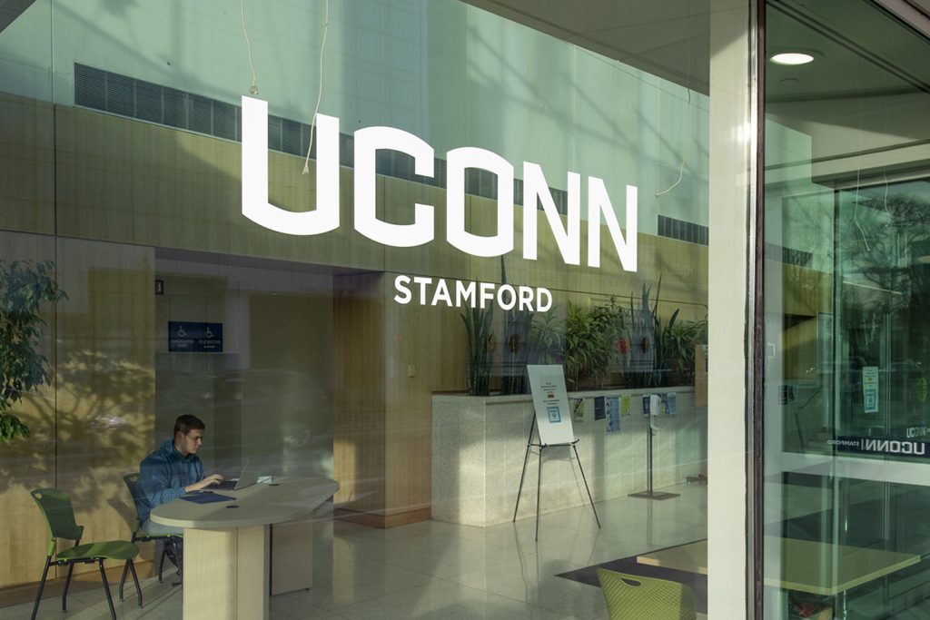 UConn Stamford sign on glass entryway.