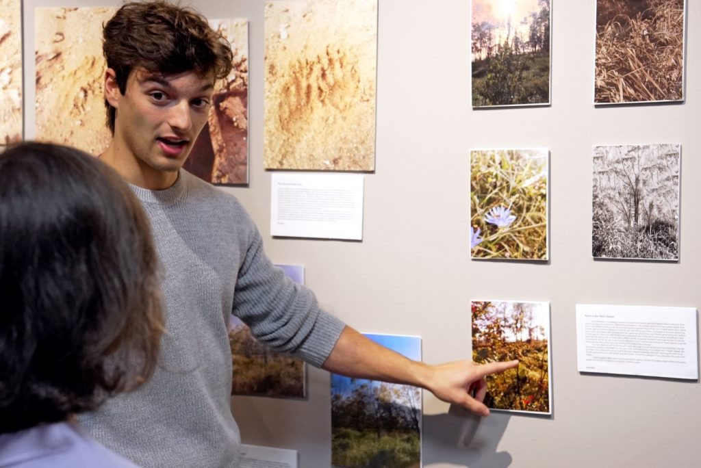 Male student presents work at exhibit