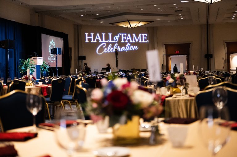 A ballroom with tables set and the words 