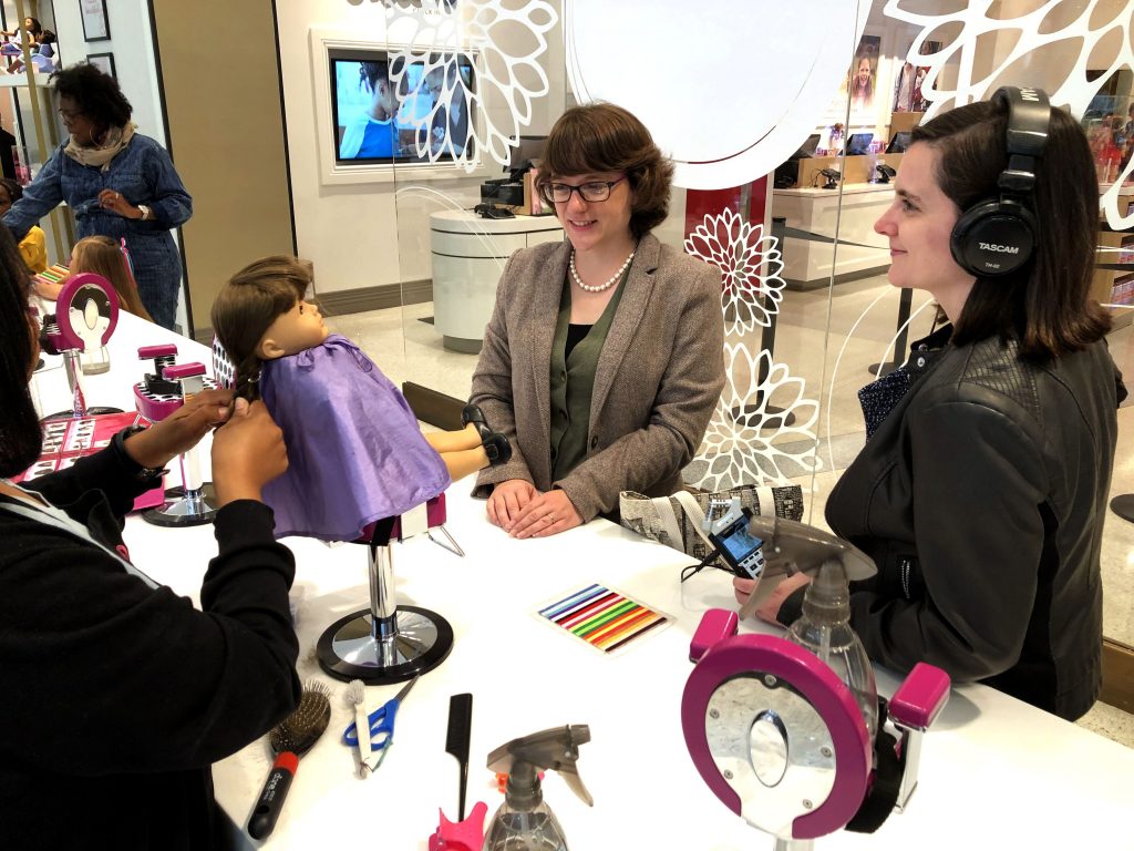 Allison Horrocks and Mary Mahoney sit in the American Girl store to record a special episode of their podcast