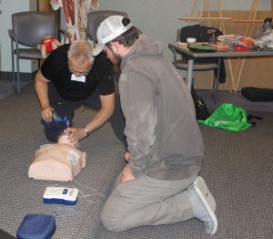 John Genther, right, watches a demonstration of CPR techniques on a mannequin during the Oct. 24 first aid and CPR training at UConn Avery Point.