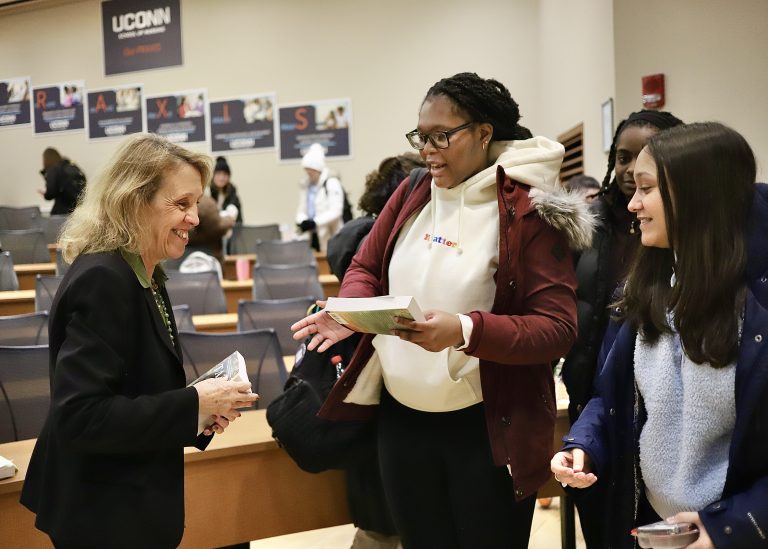 UConn Students receive a copy of the book Take My Hand from Dean Dickson.