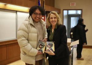 UConn student Zaheer Turtem accepts book from Dean Dickson.