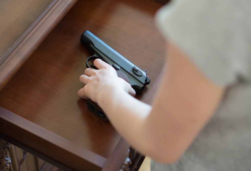 A child finds a pistol hidden in a drawer at home.