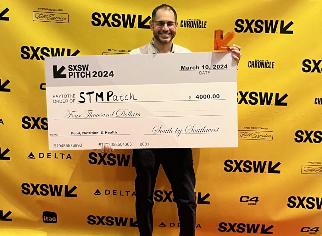 UConn entrepreneur Jasdeep Singh holds the giant check that signifies his victory at a business pitch competition held at the SXSW conference.