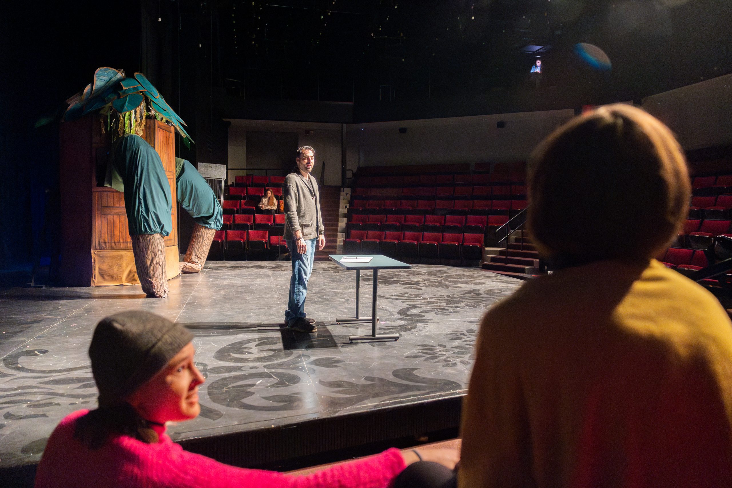 Cast and crew members stand on and around the stage in the Nafe Katter theater during the production of 'Taurus.'