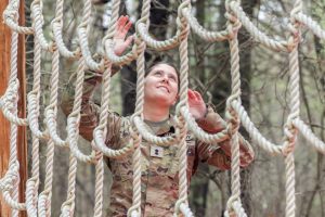 UConn Army ROTC cadet Natasha Sherwood spots another cadet climbing up the net in one of the obstacle courses at Fort Devens.