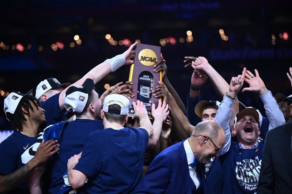 The victorious UConn men's basketball team celebrates after winning the 2024 NCAA championship.