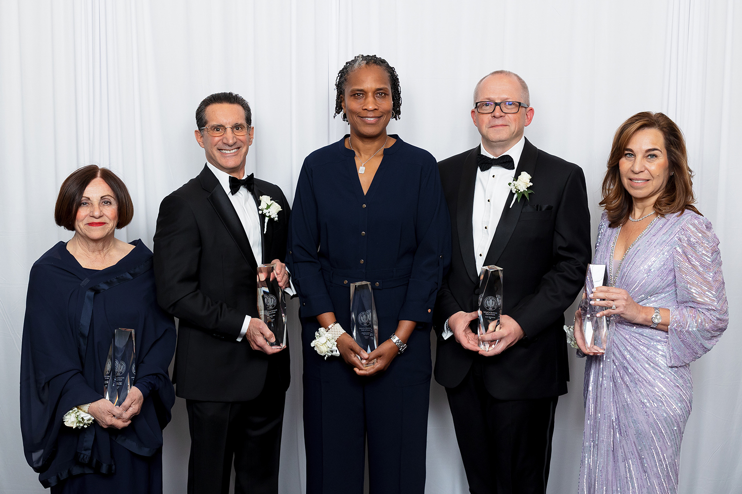 The Hall of Fame 2024 Inductees: Left to right: Antonietta “Toni’’ Boucher ’02 MBA, Randy Siller ’79, Jamelle Elliott ’96, ’96 MA, Lee McChesney ’94, and Mary Jane Fortin ’86