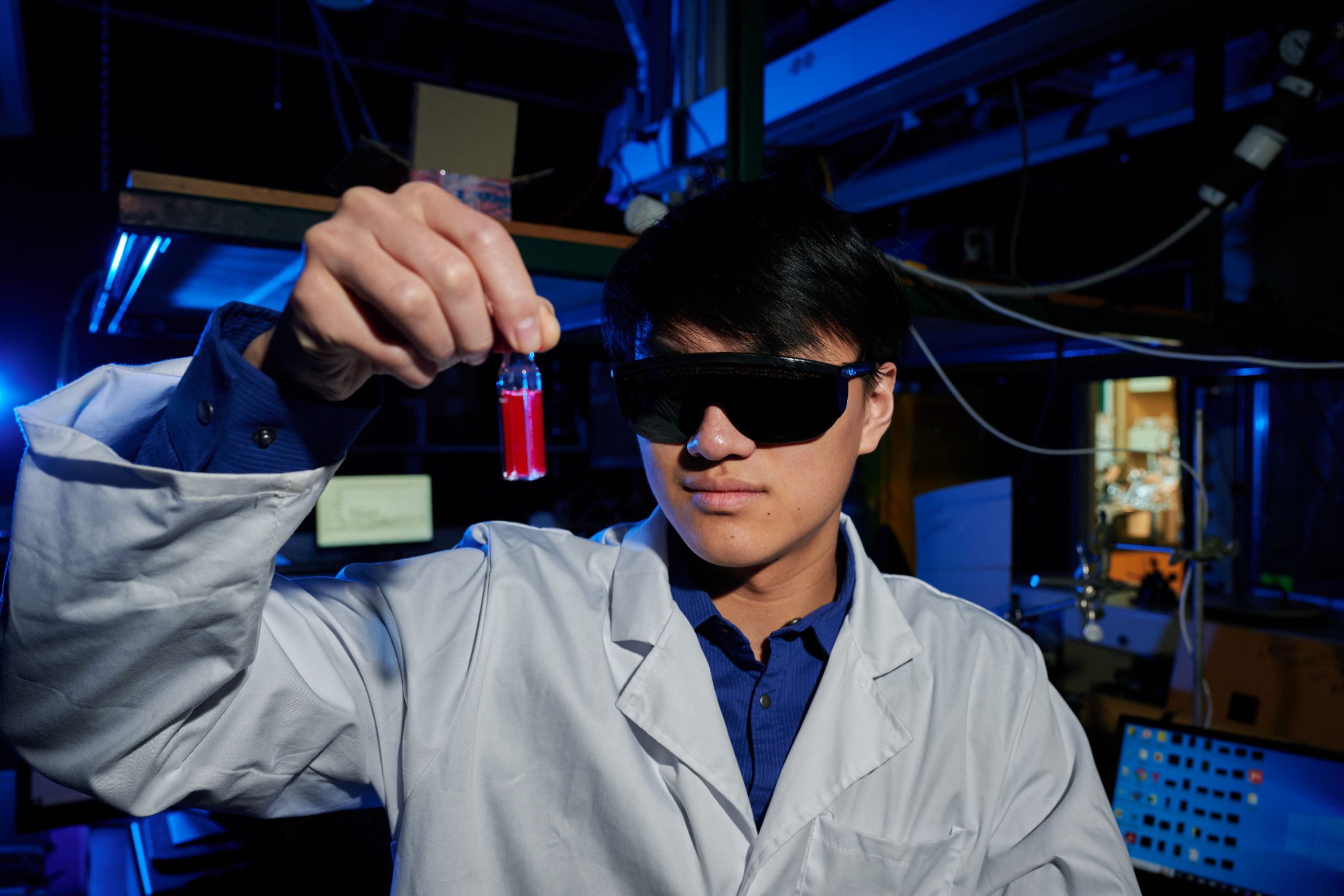 Neo Lin holds a sample in a laboratory.