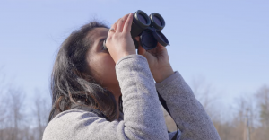 Maria B. Antony looks for birds around UConn Health.