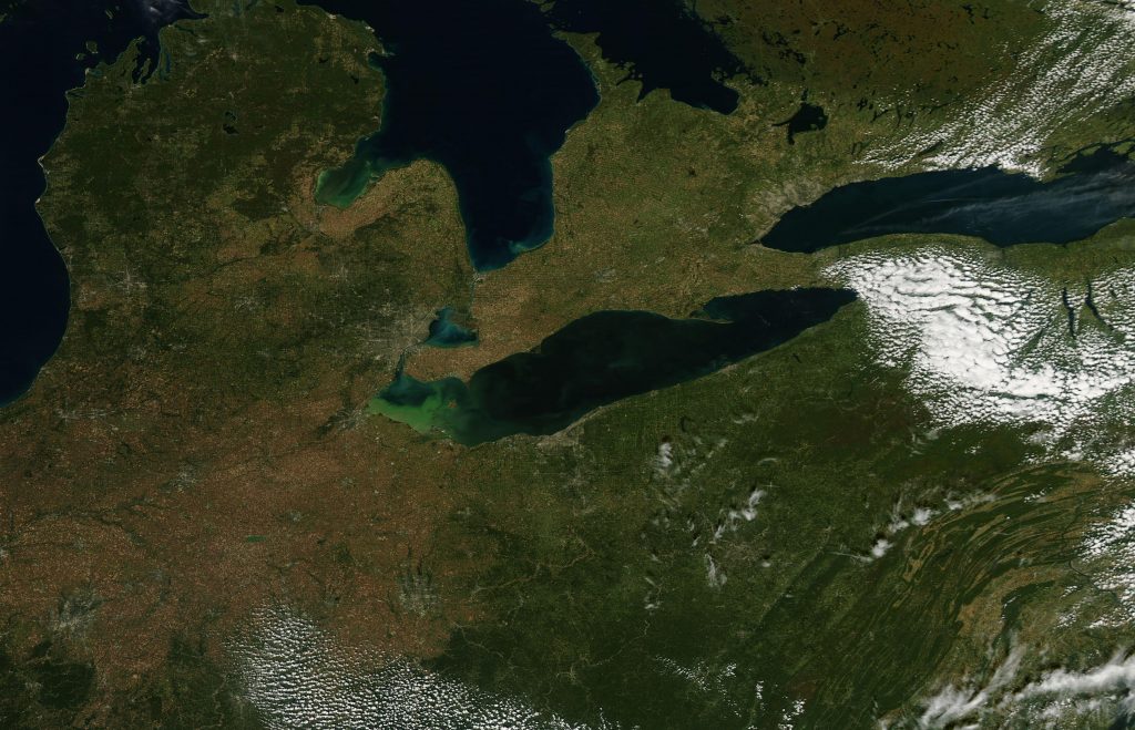 The waters of Lake Erie seem to glow green in this image taken by the Moderate Resolution Imaging Spectroradiometer (MODIS) on NASA’s Aqua satellite.