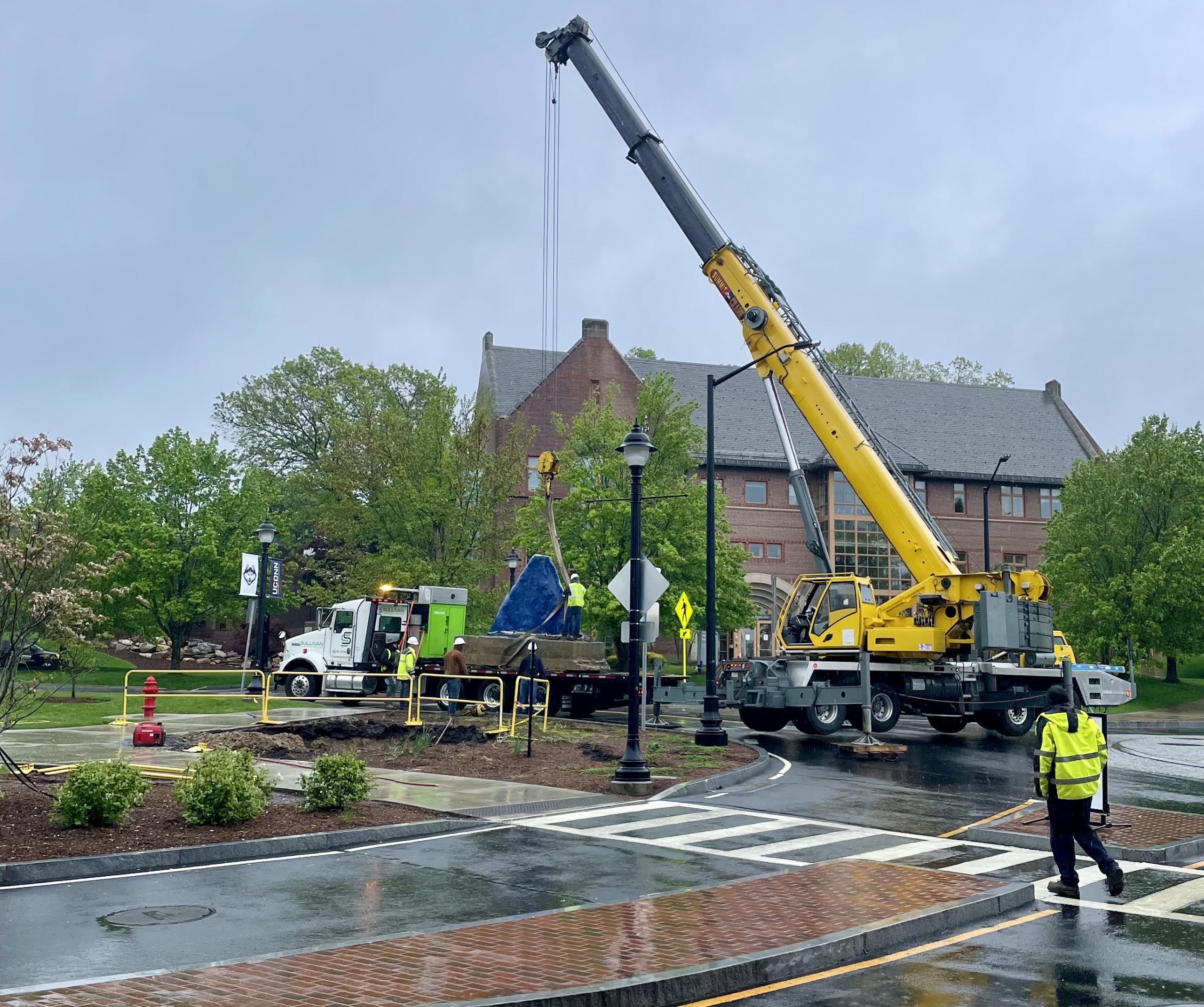 A crane lifts the UConn Spirit Rock from its current location.