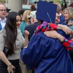 A graduate hugs a loved one