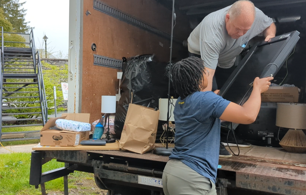 Sydney Seldon loads a donated TV into a truck