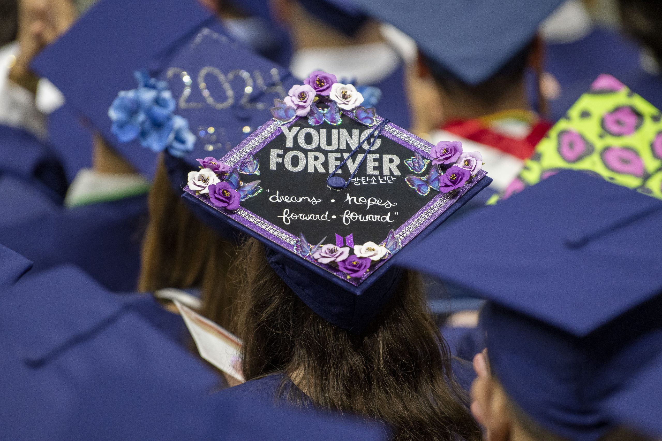 A graduation cap decorated with the words "Young Forever."