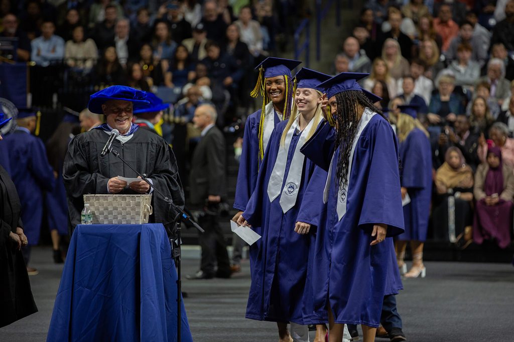 Aaliyah Edwards '24 (CLAS), Paige Bueckers '24 (CLAS), and Azzi Fudd (CLAS) laugh during commencement ceremony.