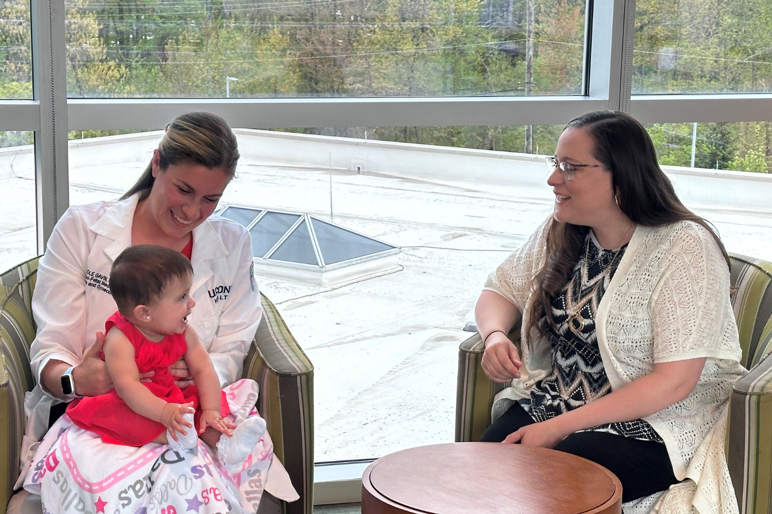 Dr. Nicole Gavin sits with her patients, mom Shana Suarez and baby daughter Dallas.