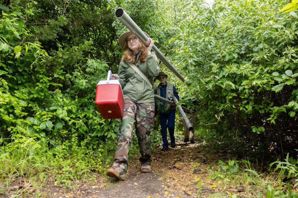 UConn and Southern Connecticut State University anthropology students and faculty help carry equipment for the soil coring collection on Grannis Island.