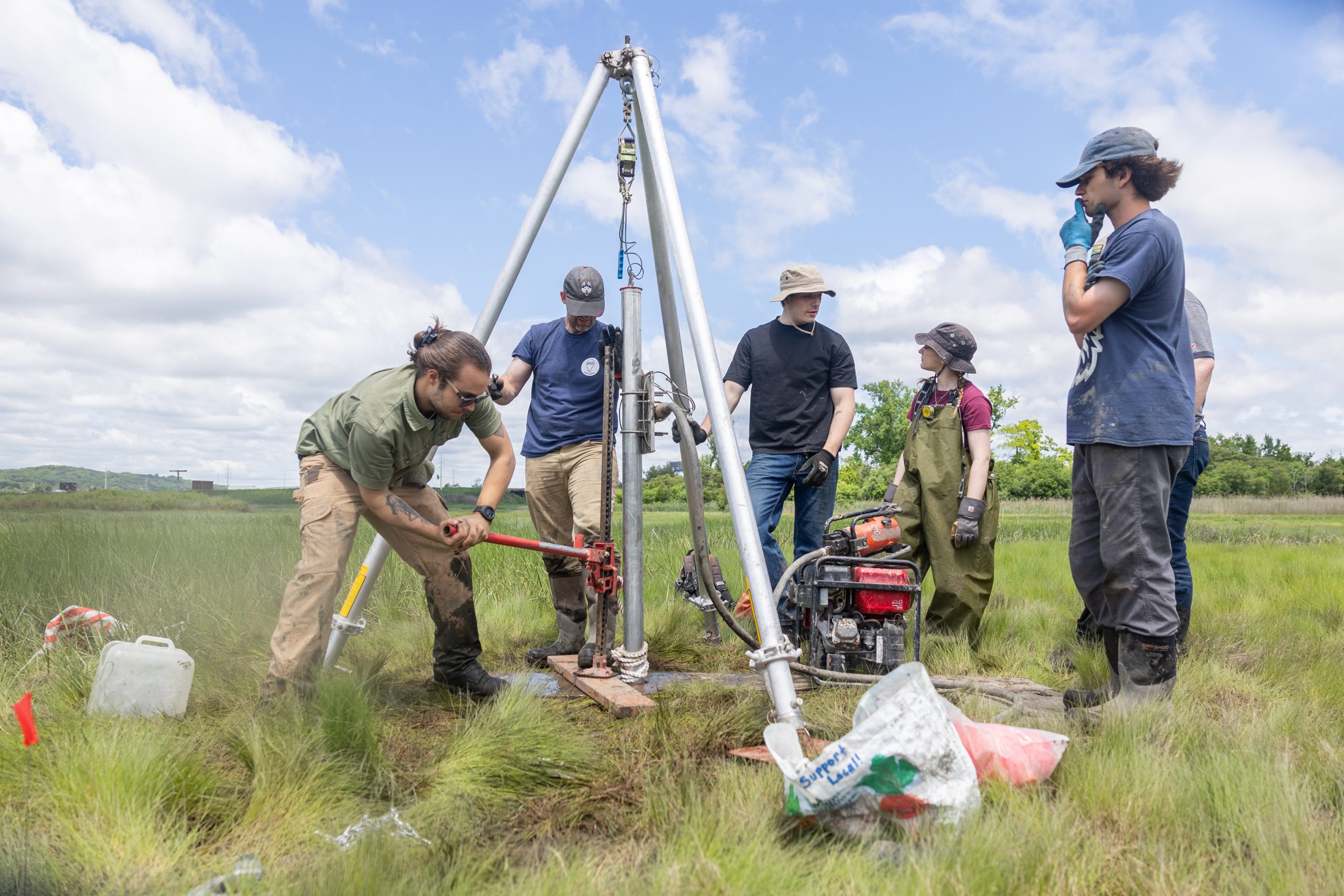 William Ouimet, associate professor of geography at UConn, and a team of students collect a soil core on Grannis Island in New Haven with a 24-foot-long pipe.
