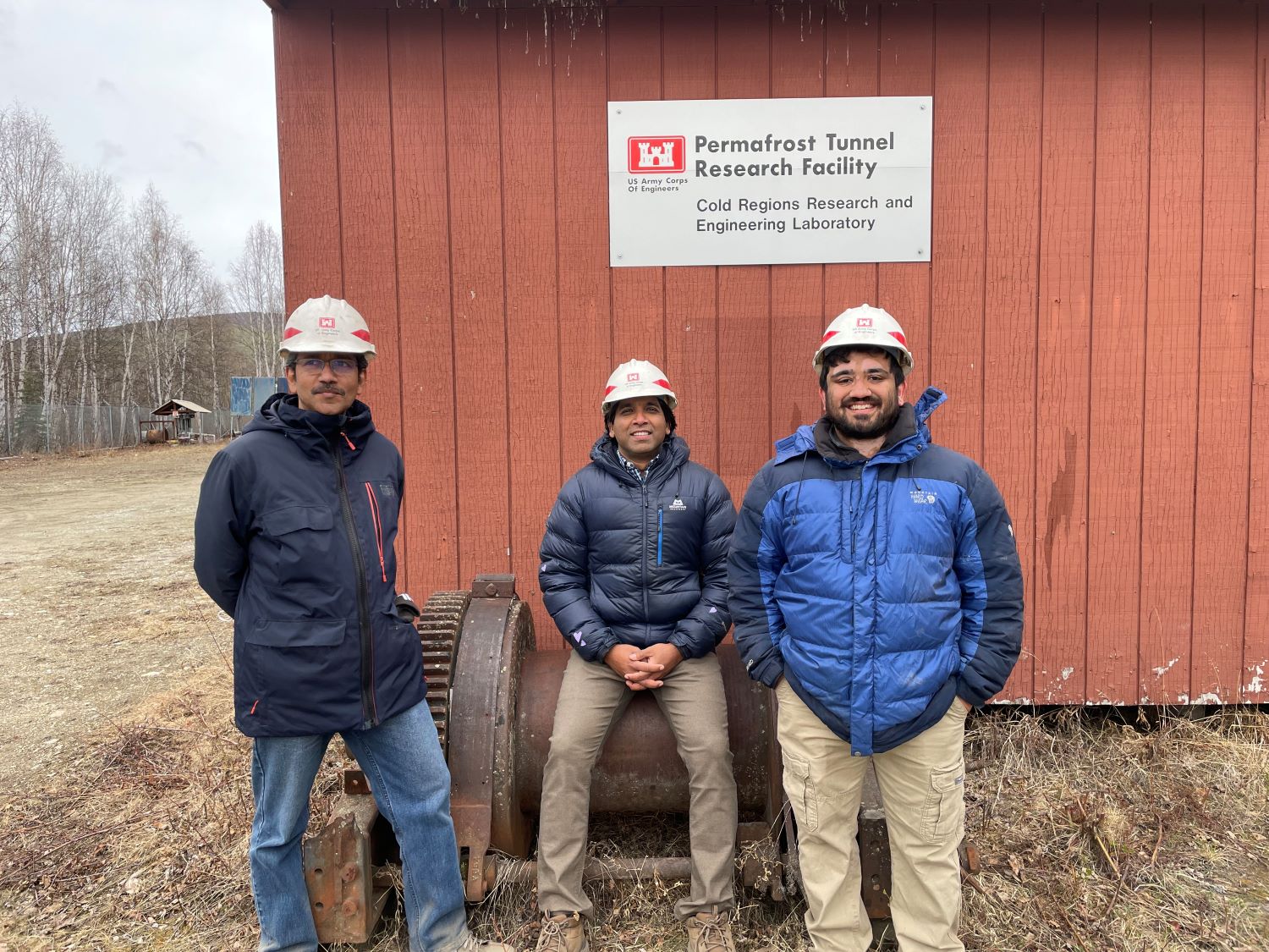 Three men in hard hats at the US Army Corps of Engineers Permafrost Tunnel Research Facility