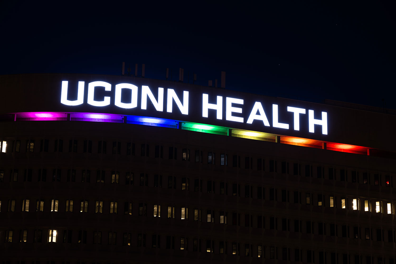 UConn Health building sign lit in rainbow colors for Pride Month